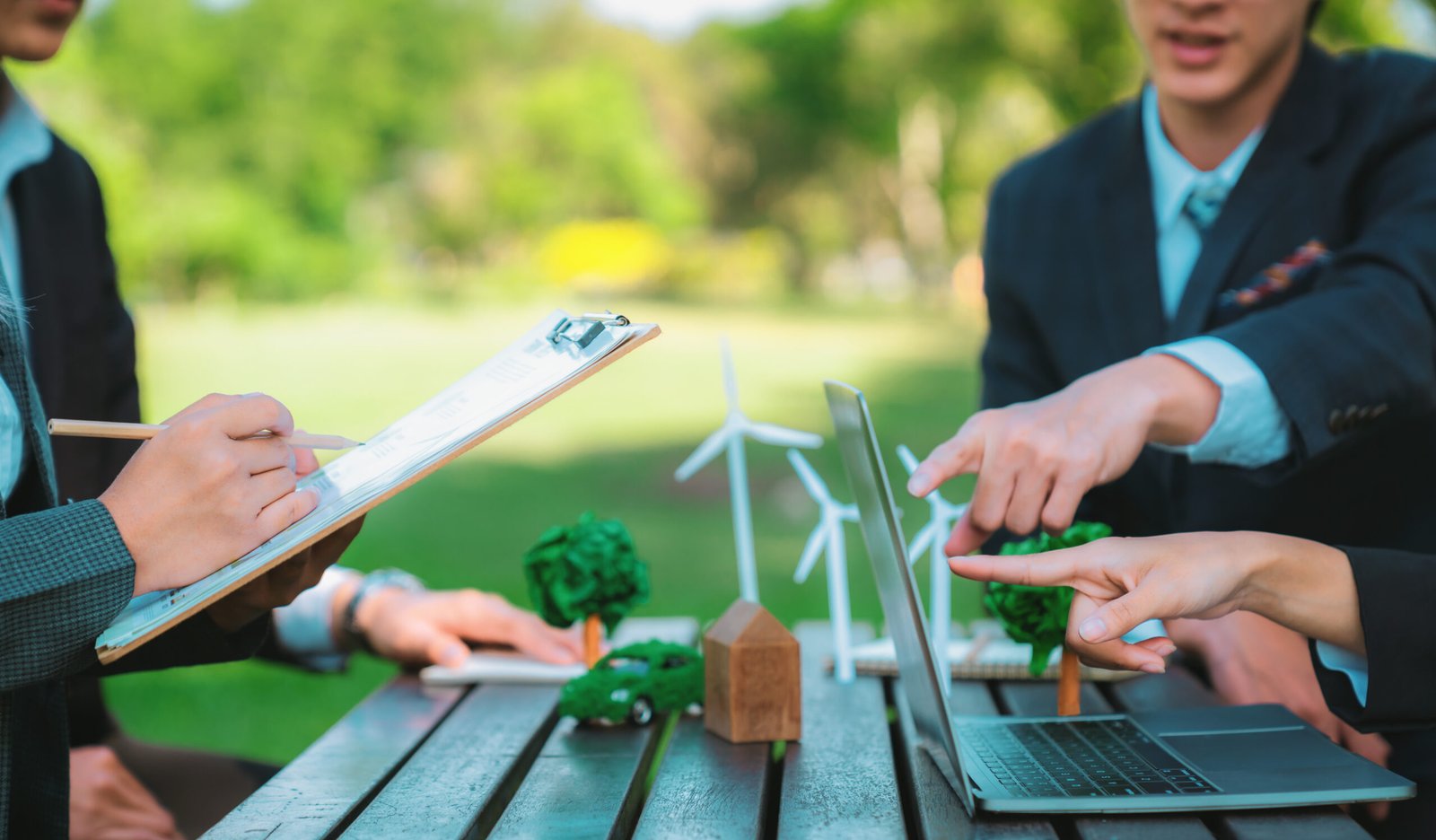 Group of asian business people presenting environmentally friendly development plan and sustainable technology project for greener future, establishing outdoor eco business office at natural park.Gyre